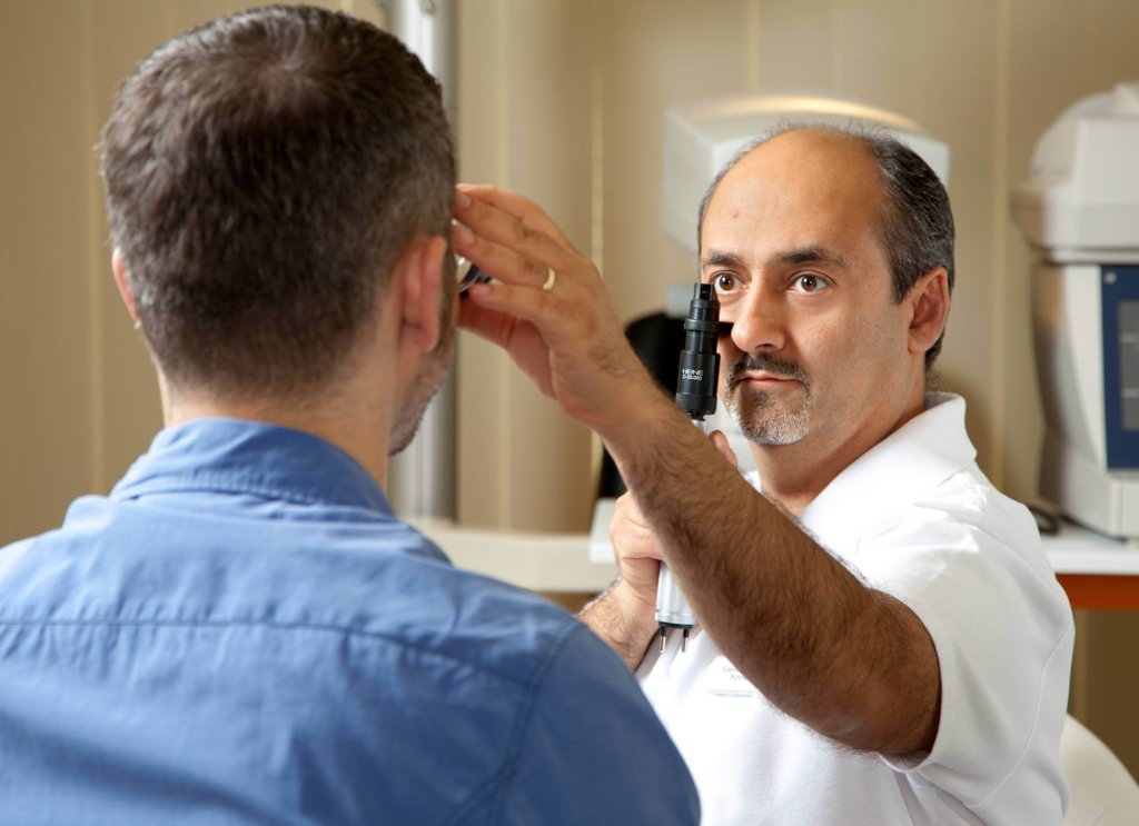 Prof. Parasta untersucht das Auge eines Patienten mit dem Ophthalmoskop. Prof. Parasta untersucht das Auge eines Patienten mit dem Ophthalmoskop.